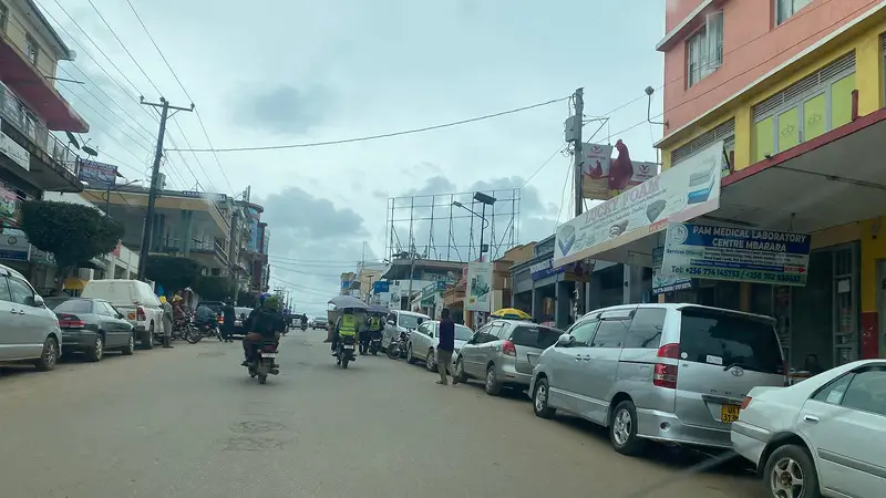 The main high street in Mbarara City with shopfronts and pedestrians