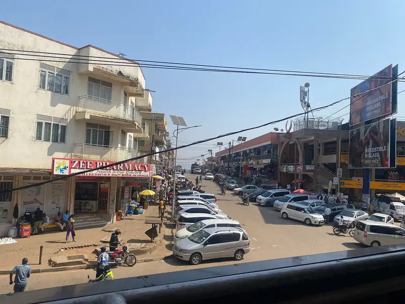 Mbaguta Street in Mbarara City with shops, traffic and pedestrians