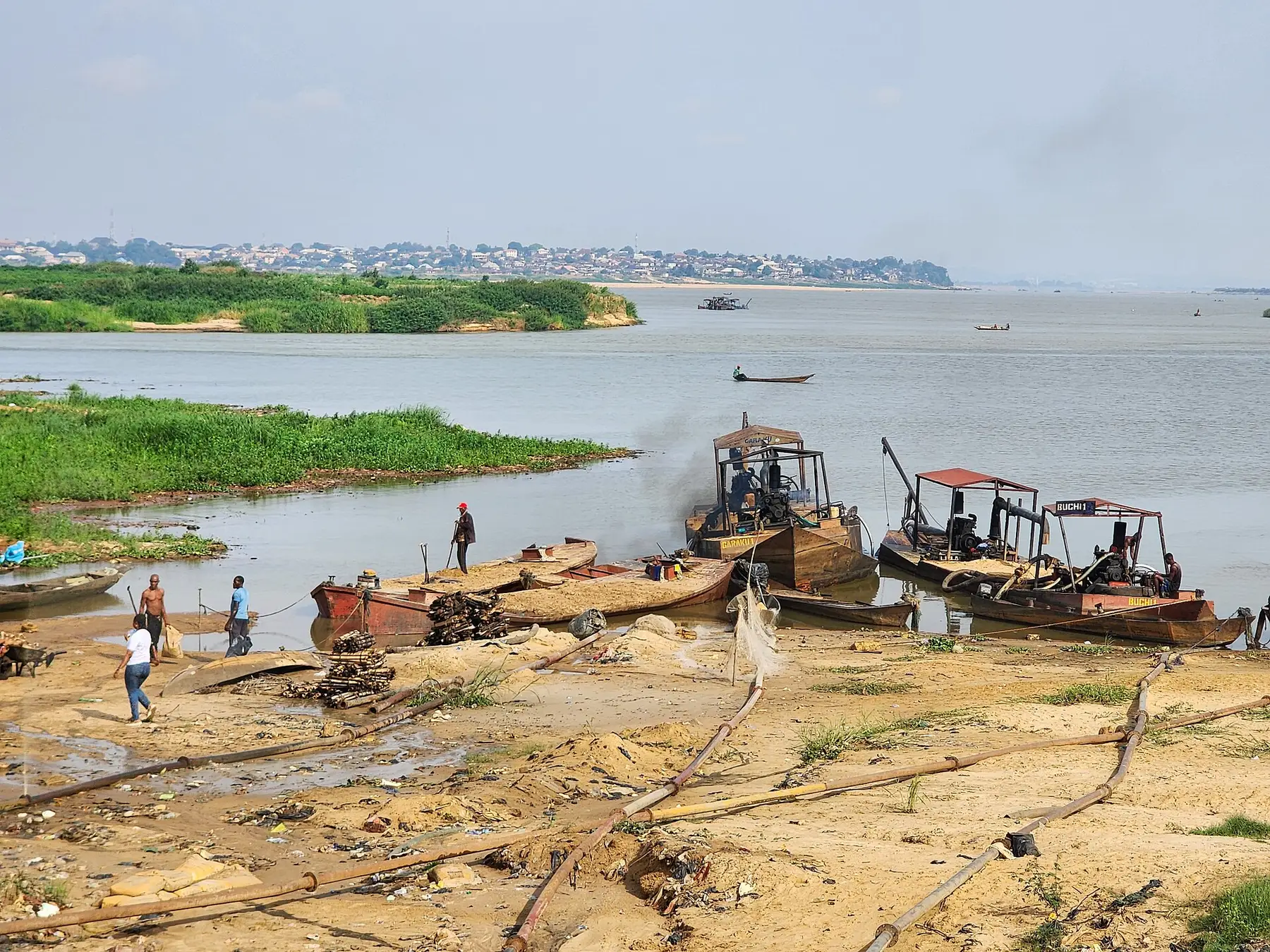 Sand being extracted from a river channel, with excavated banks visible